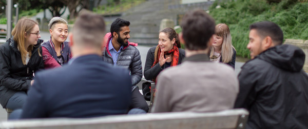 Group of young adults sitting in a circle talking